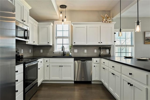16059 Fontana St Unit 205, Overland Park, KS 66085 - kitchen featuring dark countertops, tasteful backsplash, a sink, a peninsula, and stainless steel appliances