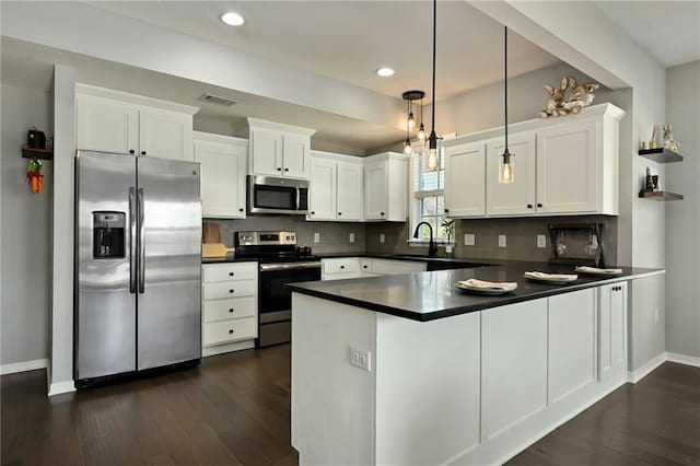 16059 Fontana St Unit 205, Overland Park, KS 66085 - kitchen featuring dark wood-style flooring, a peninsula, dark countertops, and appliances with stainless steel finishes