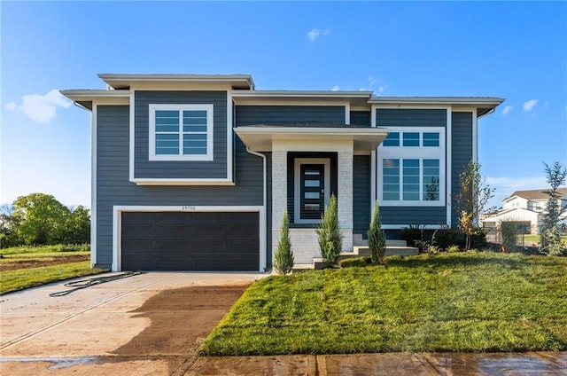 view of front facade with a garage, a front yard, concrete driveway, and brick siding