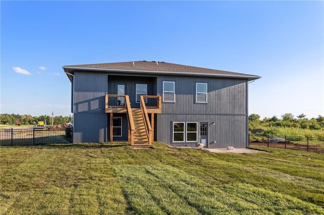 back of house featuring a deck, stairway, fence, and a lawn