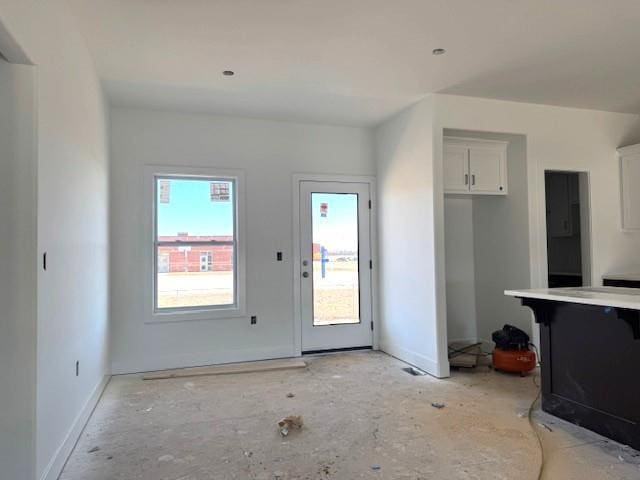 unfurnished living room with baseboards