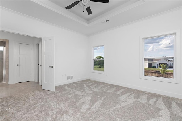 unfurnished room with crown molding, a raised ceiling, visible vents, carpet flooring, and baseboards