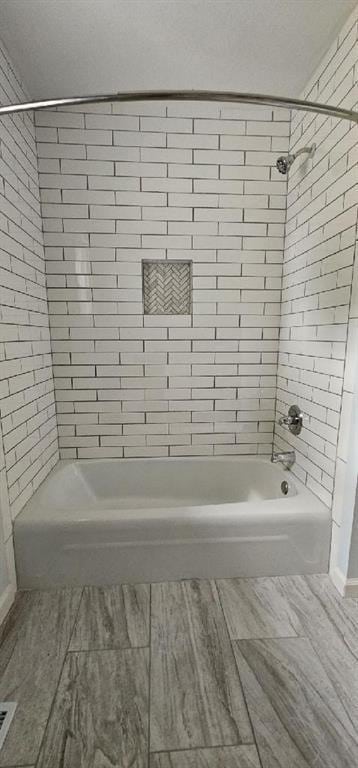 full bath featuring a textured ceiling, visible vents, and bathing tub / shower combination