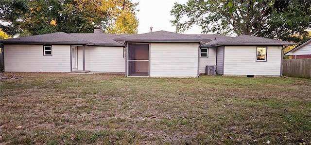 rear view of house with a lawn, a chimney, and fence