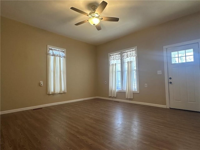 foyer with dark wood finished floors, visible vents, ceiling fan, and baseboards