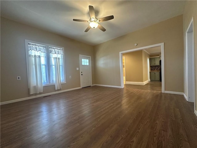 unfurnished living room featuring dark wood-style floors, visible vents, ceiling fan, and baseboards