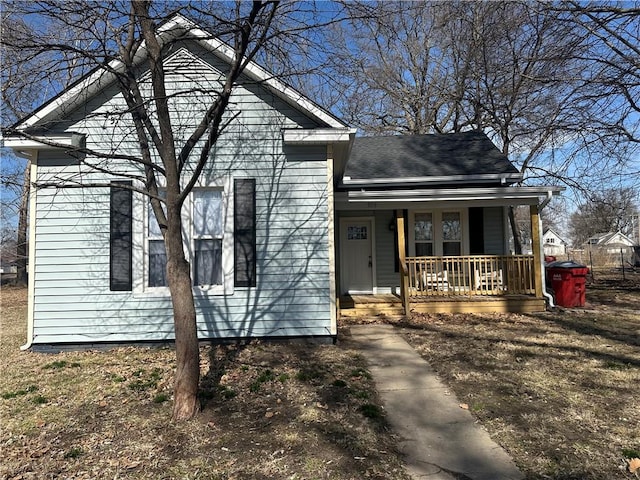 view of front of home featuring roof with shingles and a porch