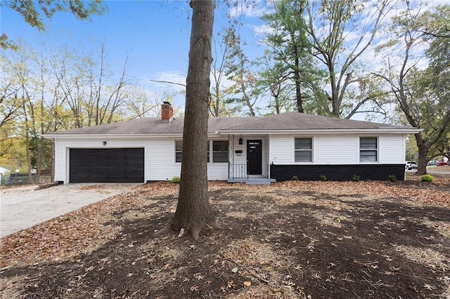 single story home featuring an attached garage, a chimney, and concrete driveway