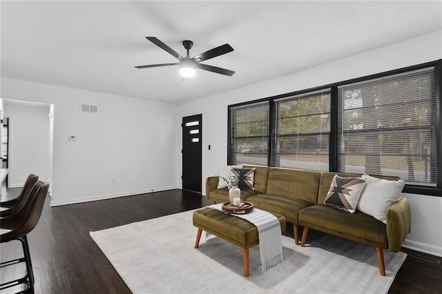 living room featuring a ceiling fan, baseboards, visible vents, and wood finished floors