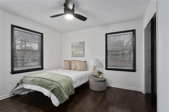 bedroom featuring visible vents, ceiling fan, baseboards, and wood finished floors