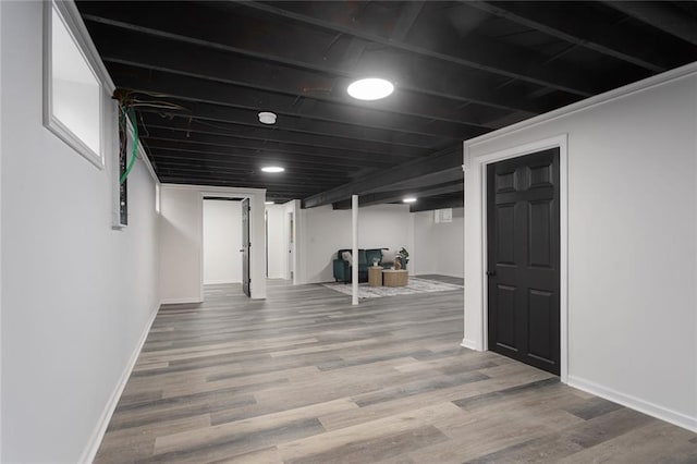 finished basement with baseboards and wood finished floors