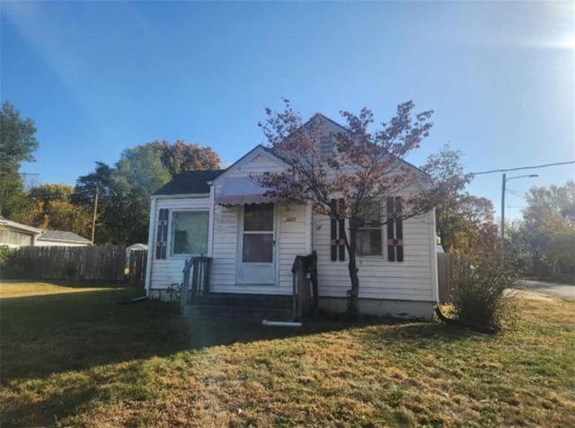 bungalow with fence and a front lawn