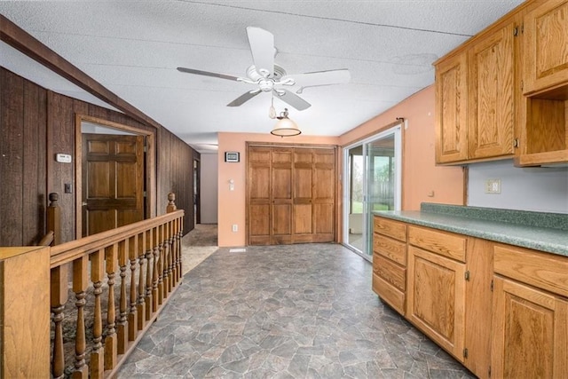 24722 Tonganoxie Dr, Leavenworth, KS 66048 - kitchen with stone finish floor, a ceiling fan, wood walls, and a textured ceiling