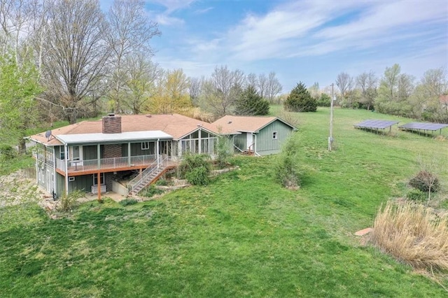 24722 Tonganoxie Dr, Leavenworth, KS 66048 - rear view of property featuring a deck, a chimney, a sunroom, a yard, and stairway