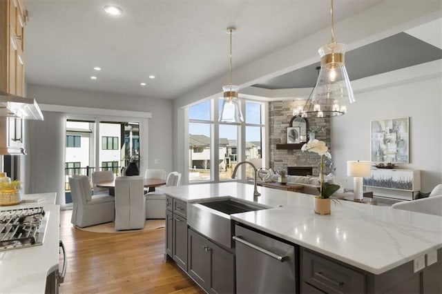 kitchen with light wood-style floors, gray cabinets, open floor plan, and dishwasher