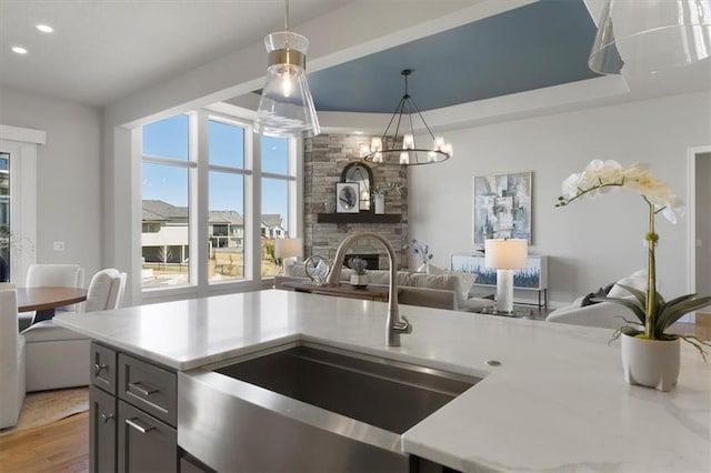 kitchen with light wood-type flooring, a fireplace, open floor plan, and a sink