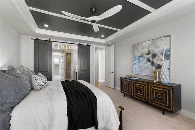 bedroom featuring a tray ceiling, light colored carpet, a barn door, connected bathroom, and baseboards