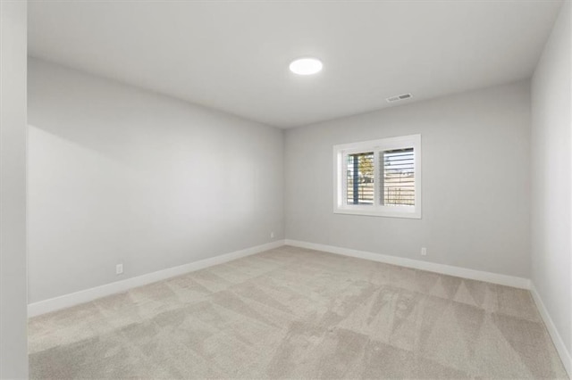 carpeted empty room with visible vents and baseboards