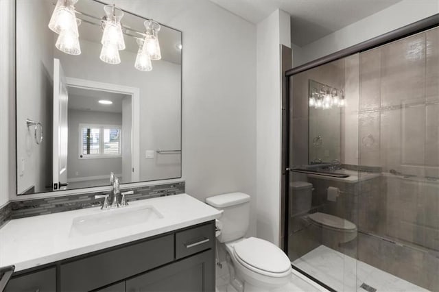 full bathroom featuring a stall shower, vanity, and toilet