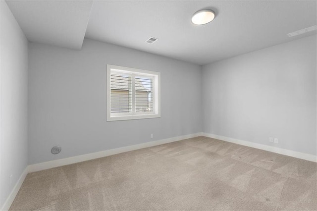 spare room featuring baseboards, visible vents, and carpet flooring