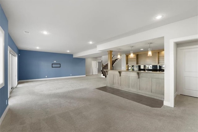 unfurnished living room with carpet, stairs, and recessed lighting