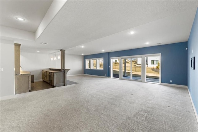 unfurnished living room featuring recessed lighting, ornate columns, carpet flooring, and baseboards