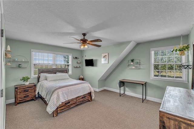 carpeted bedroom with ceiling fan, a textured ceiling, and baseboards