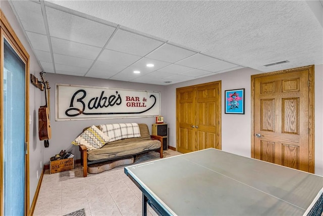 rec room with a paneled ceiling, tile patterned flooring, visible vents, and baseboards