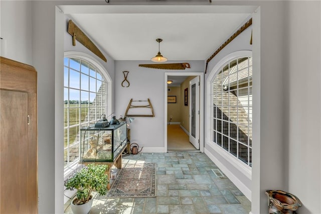 doorway featuring baseboards and stone finish floor