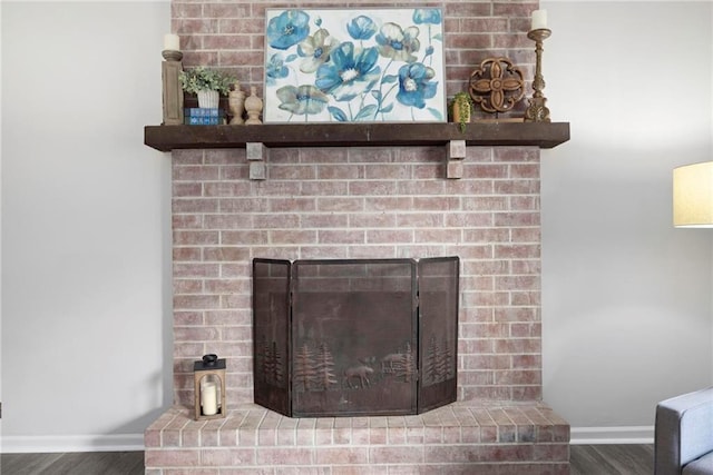 interior details featuring wood finished floors, a fireplace, and baseboards