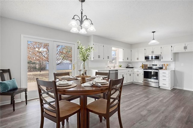 dining room with dark wood-style floors, baseboards, and a textured ceiling