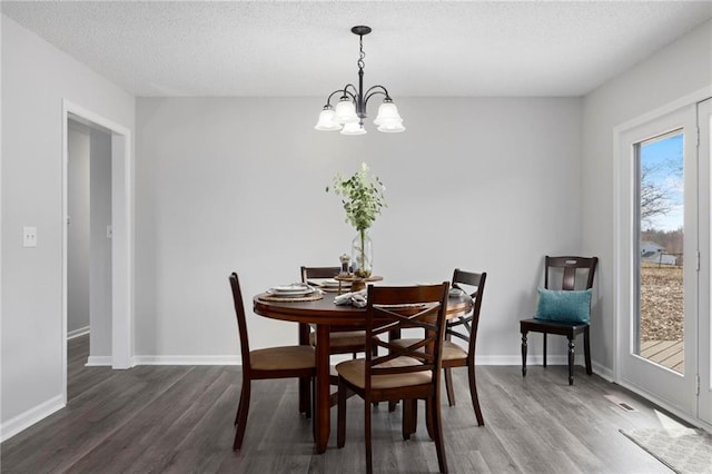 dining area with a chandelier, baseboards, and wood finished floors