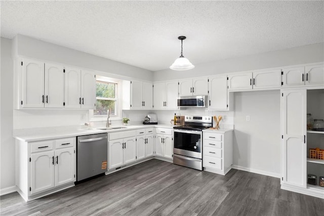 kitchen featuring white cabinets, dark wood-style flooring, appliances with stainless steel finishes, and a sink