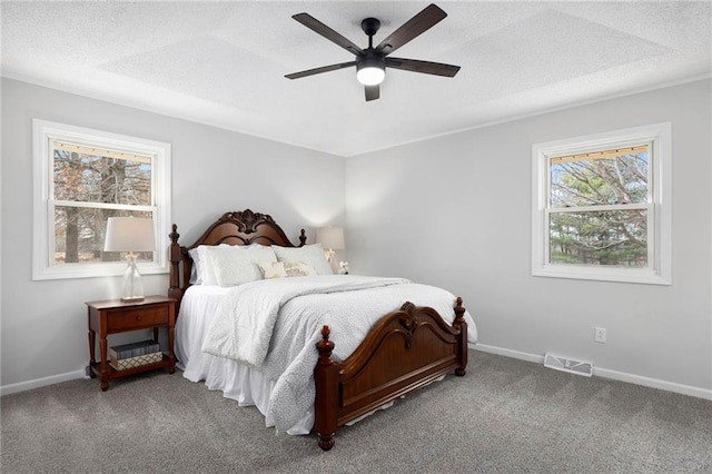 carpeted bedroom featuring visible vents, baseboards, a textured ceiling, and ceiling fan