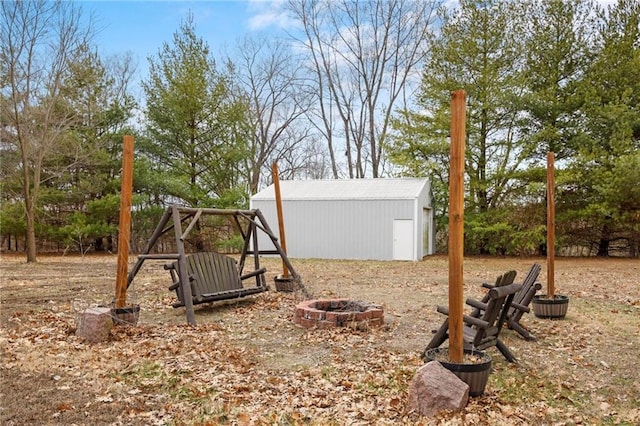 view of yard with a fire pit and an outdoor structure