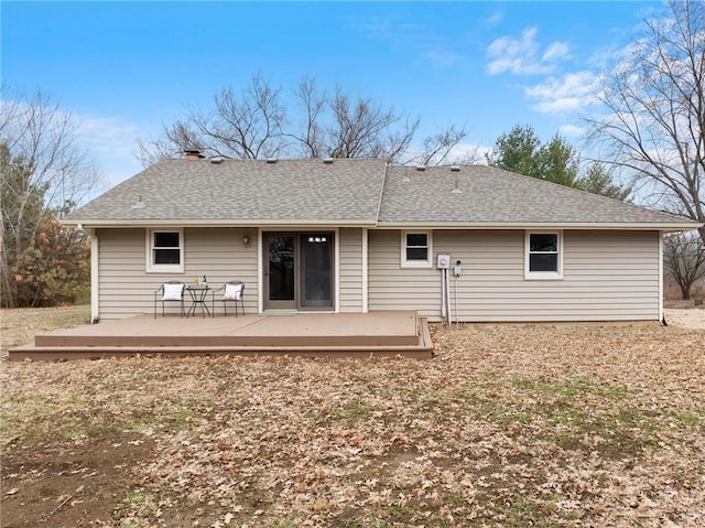 rear view of property featuring a deck and a shingled roof