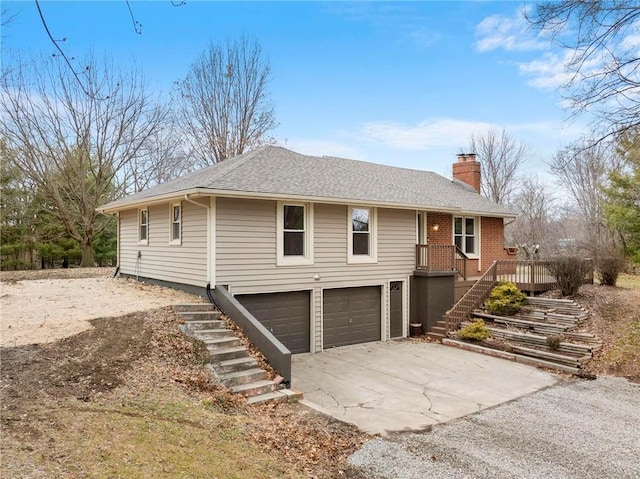 view of front of home featuring roof with shingles, an attached garage, a chimney, stairs, and concrete driveway