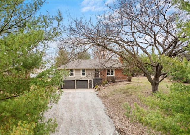 single story home with stairway, brick siding, gravel driveway, and an attached garage