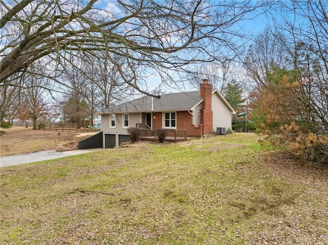 single story home with driveway, a chimney, a front lawn, a garage, and brick siding