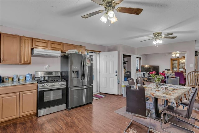 kitchen with under cabinet range hood, appliances with stainless steel finishes, light countertops, and dark wood-type flooring