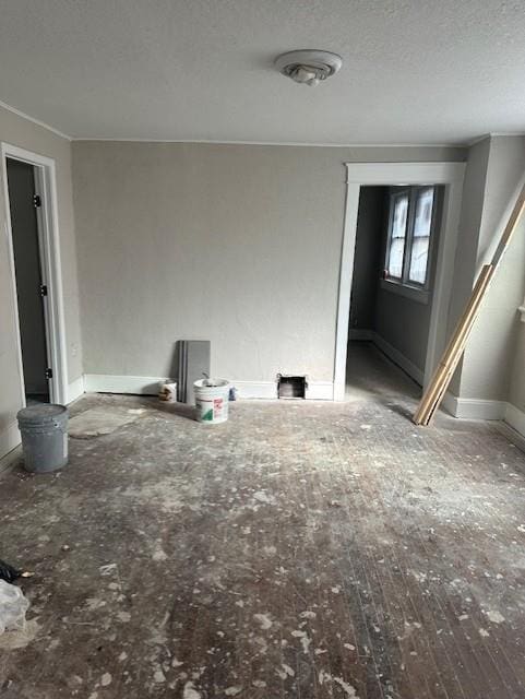 interior space featuring a textured ceiling and baseboards