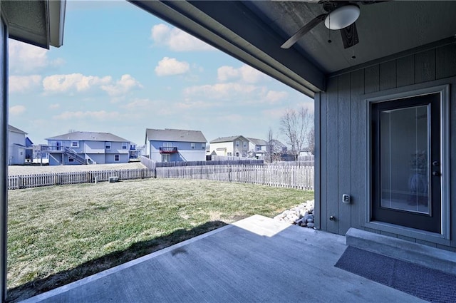 view of yard featuring a fenced backyard, a residential view, ceiling fan, and a patio area