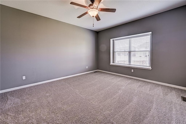 carpeted empty room with visible vents, a ceiling fan, and baseboards