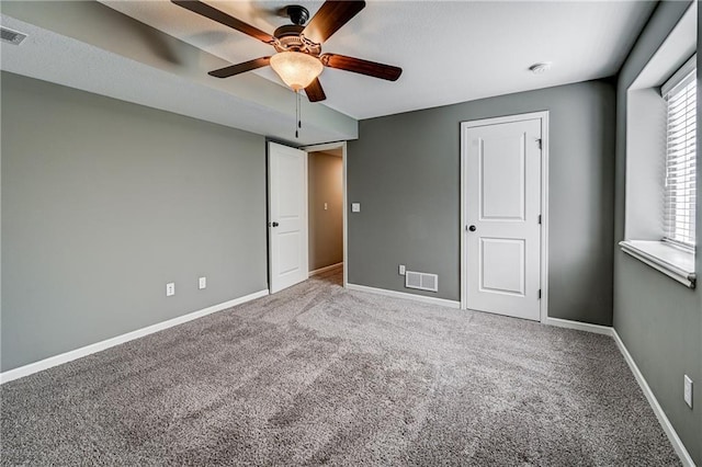 unfurnished bedroom with carpet flooring, baseboards, visible vents, and ceiling fan