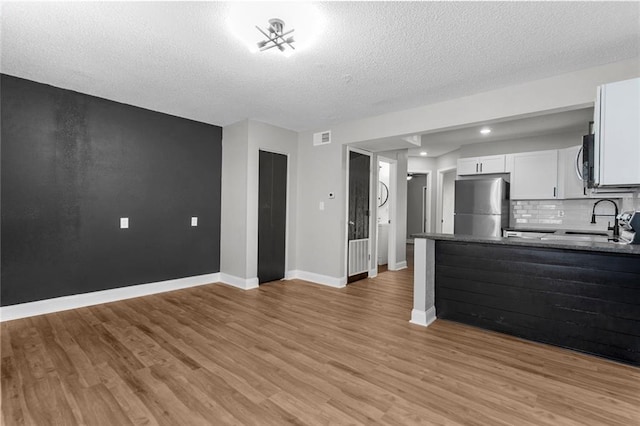 kitchen with light wood finished floors, visible vents, appliances with stainless steel finishes, and a sink