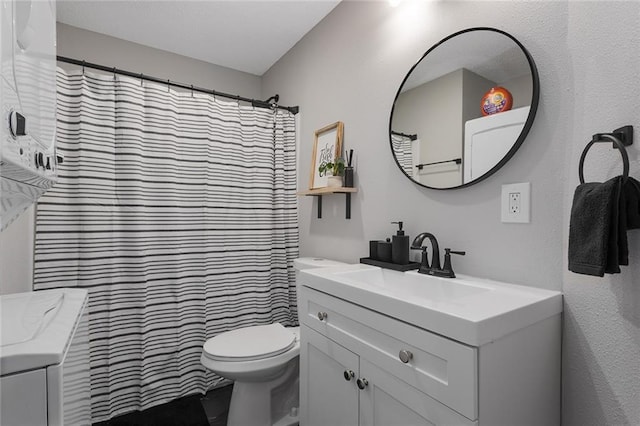 bathroom with curtained shower, vanity, and toilet