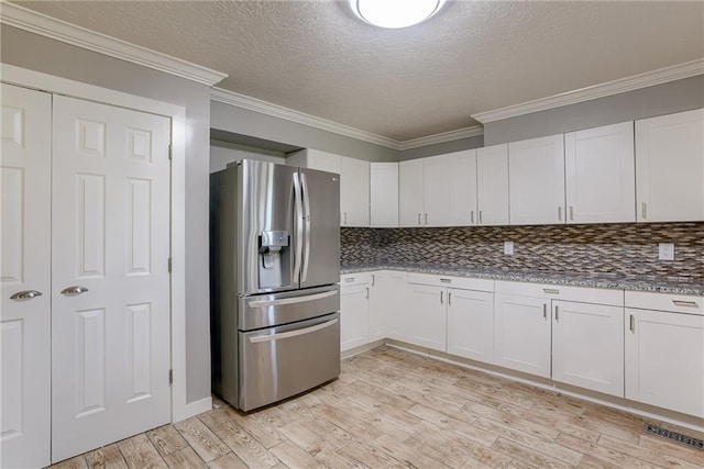 kitchen with crown molding, light wood-type flooring, stainless steel refrigerator with ice dispenser, and decorative backsplash