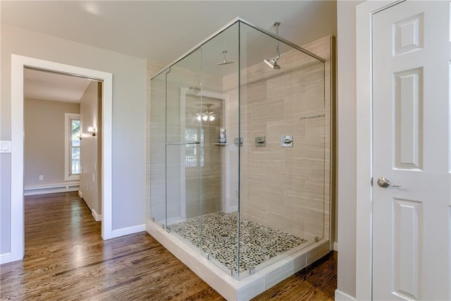 bathroom with a stall shower and wood finished floors