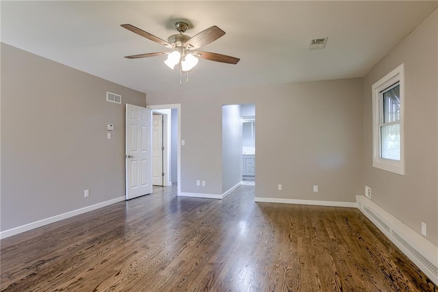 unfurnished room with a ceiling fan, visible vents, dark wood finished floors, and baseboards