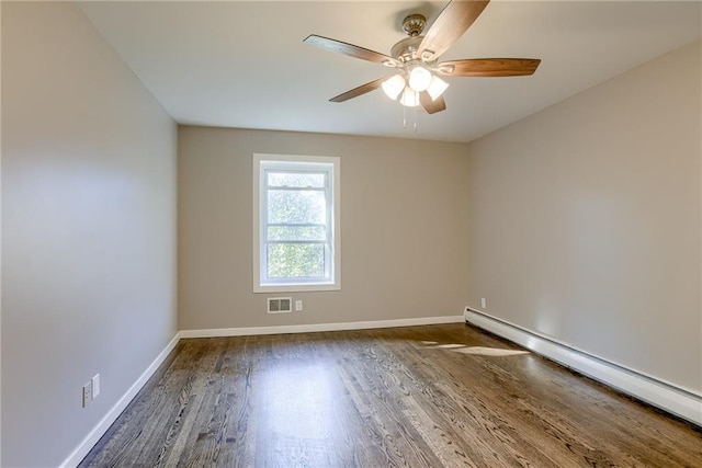 empty room featuring baseboards, visible vents, a ceiling fan, wood finished floors, and baseboard heating